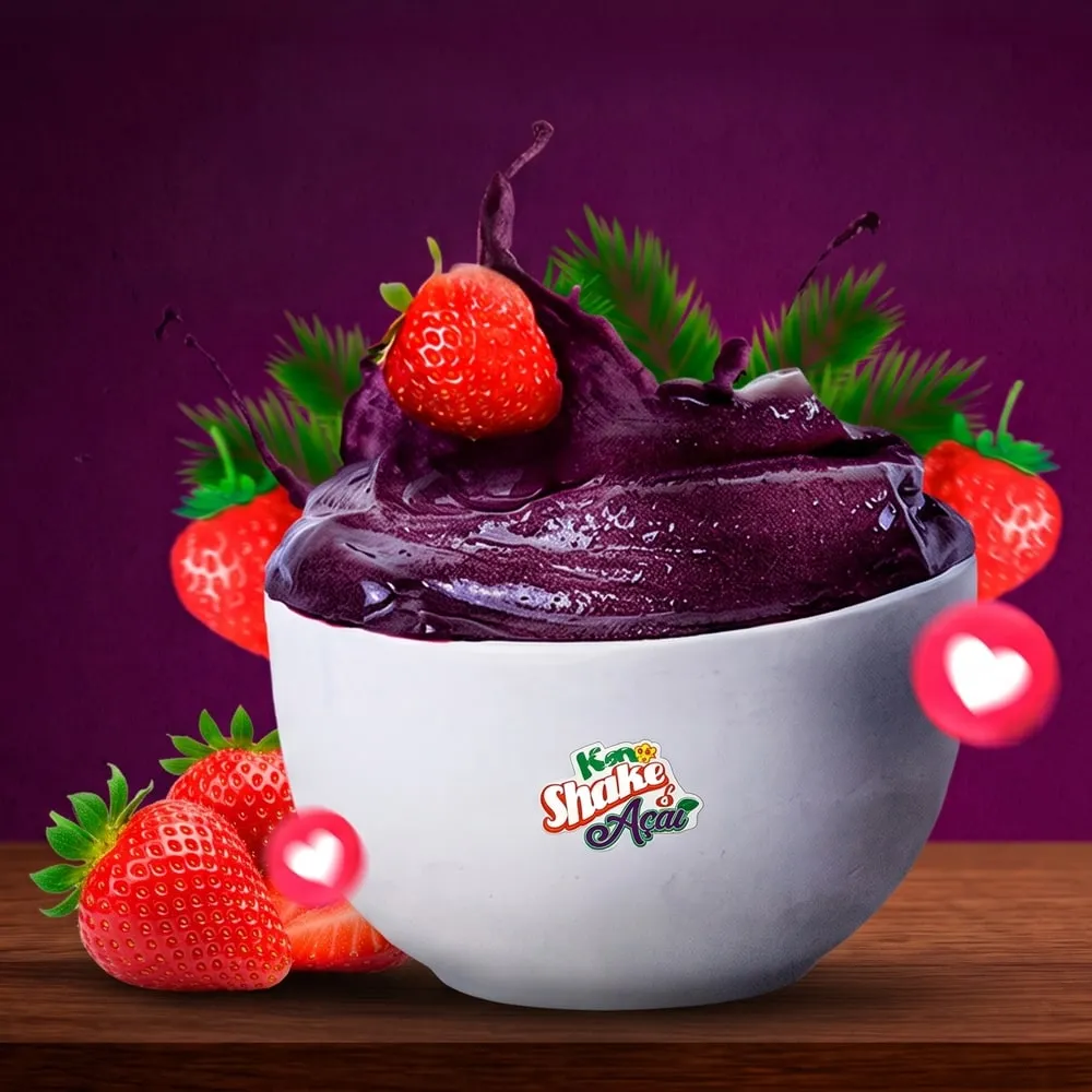 Tigela branca cheia de açaí cremoso com morango por cima, cercada de morangos